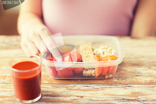 Image of close up of woman with vegetarian food in box