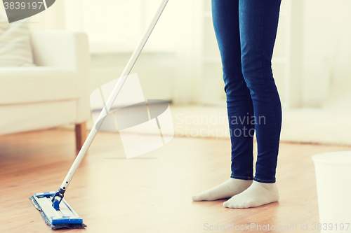 Image of close up of woman with mop cleaning floor at home