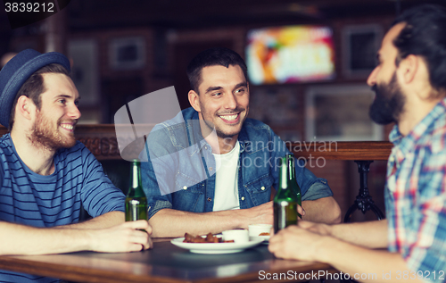 Image of happy male friends drinking beer at bar or pub