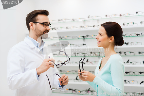 Image of woman and optician showing glasses at optics store