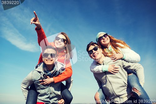 Image of happy friends in shades having fun outdoors