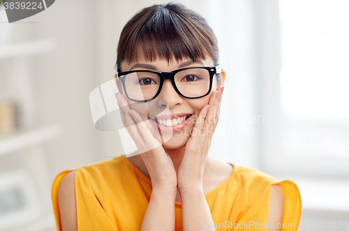 Image of happy asian young woman in glasses at home