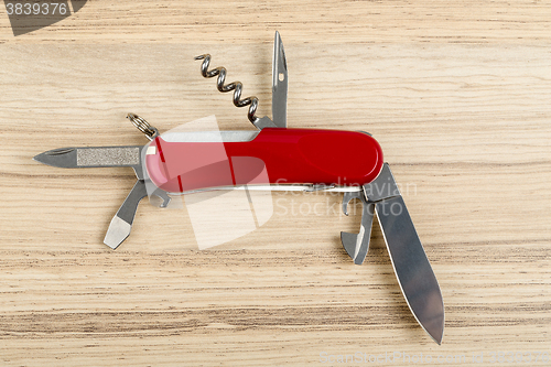 Image of Multipurpose knife on wooden background