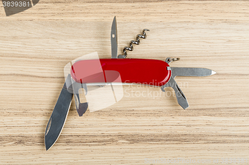 Image of Multipurpose knife on wooden background