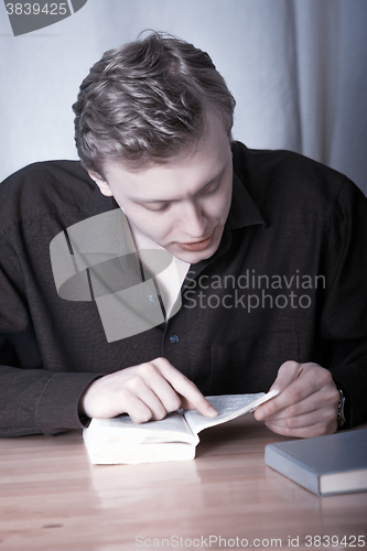 Image of The young man bent over the book