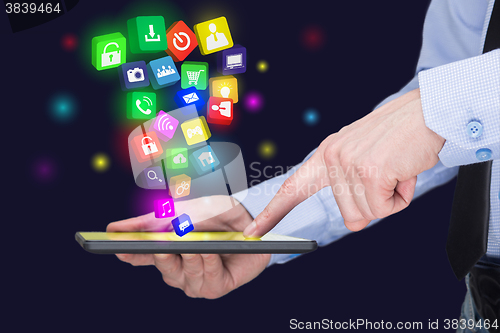 Image of Businessman holding a tablet pc with mobile applications icons on virtual screen . Internet and business concept.