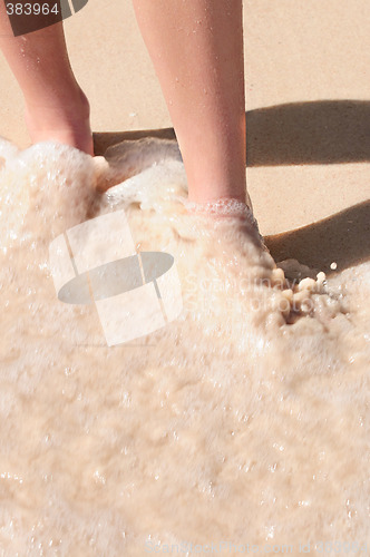 Image of Feet washed in ocean wave