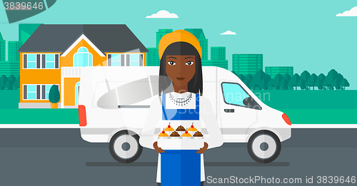 Image of Baker holding box of cakes.