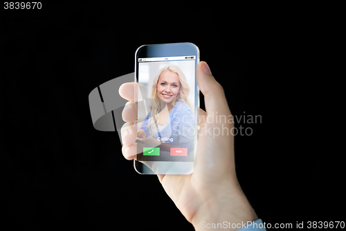 Image of close up of hand with incoming call on smartphone