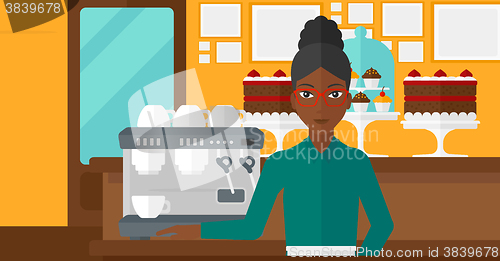 Image of Barista standing near coffee maker.
