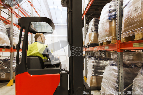 Image of man on forklift loading cargo at warehouse