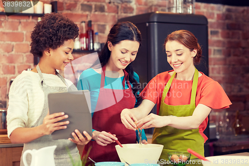 Image of happy women with tablet pc in kitchen