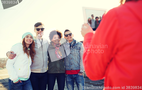 Image of happy teenage friends with tablet pc photographing