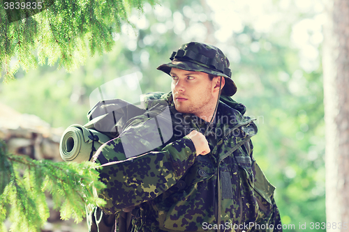 Image of young soldier with backpack in forest