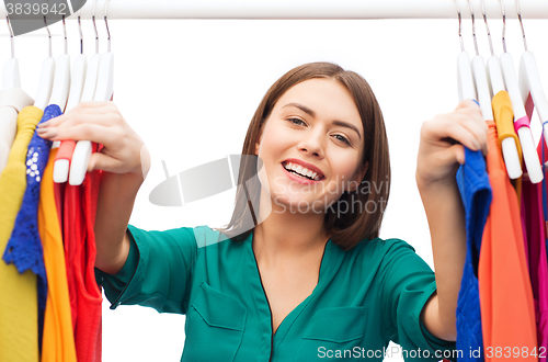 Image of happy woman choosing clothes at home wardrobe