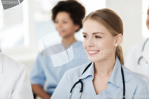 Image of happy doctor over group of medics at hospital