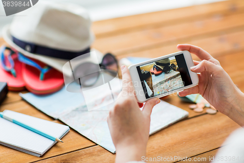 Image of close up of woman with smartphone and travel stuff