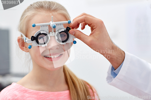 Image of optician with trial frame and girl at clinic