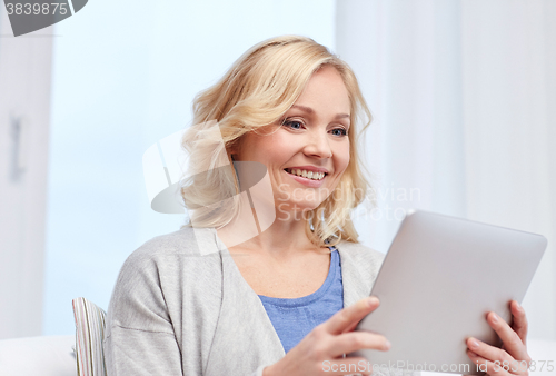 Image of happy middle aged woman with tablet pc at home