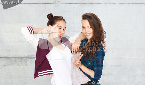 Image of happy pretty teenage girls showing peace hand sign