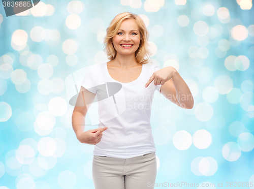 Image of smiling woman in white t-shirt pointing to herself