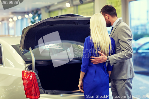 Image of happy couple choosing car in auto show or salon