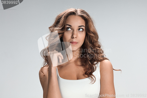Image of The happy thoughtful woman on gray background