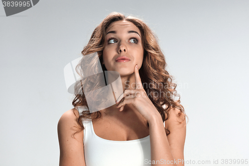 Image of The happy thoughtful woman on gray background