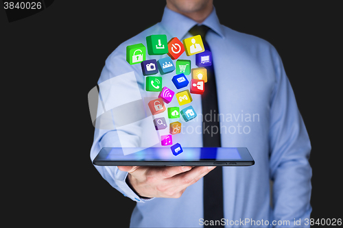 Image of Businessman holding a tablet pc with mobile applications icons on virtual screen . Internet and business concept.