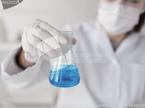 Image of close up of woman with flask making test in lab