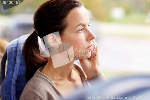 Image of woman in travel bus calling on smartphone