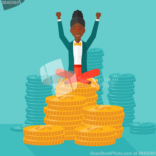 Image of  Happy business woman sitting on coins.