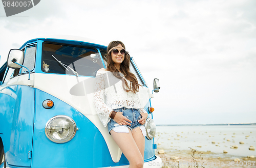 Image of smiling young hippie woman with minivan car