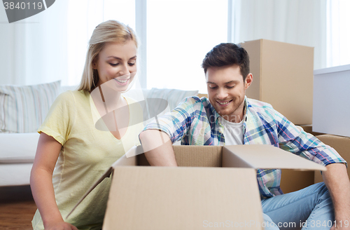 Image of smiling couple with big boxes moving to new home