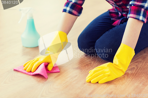 Image of close up of woman with rag cleaning floor at home