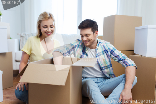 Image of smiling couple with big boxes moving to new home