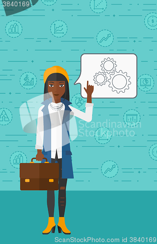 Image of Business woman pointing at cogwheels.