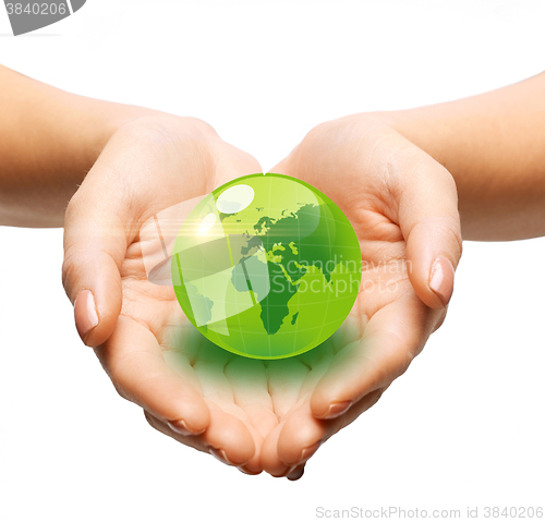 Image of close up of woman holding green globe in her hands