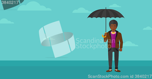 Image of Businessman standing with umbrella.