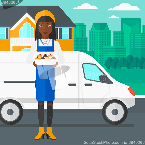 Image of Baker holding box of cakes.