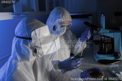 Image of close up of scientists with test samples in lab