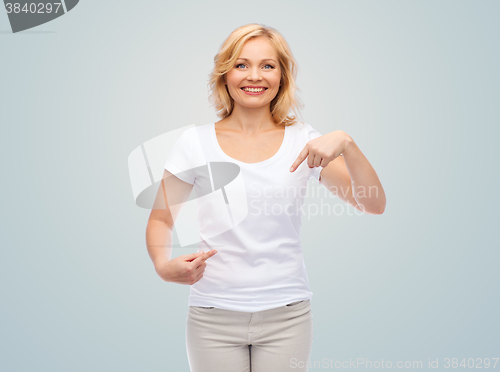 Image of smiling woman in white t-shirt pointing to herself