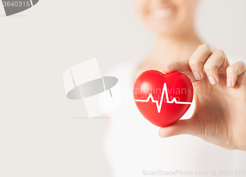 Image of close up of hand with cardiogram on red heart