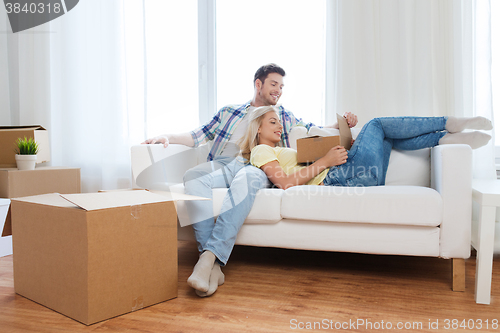 Image of happy couple with big cardboard boxes at new home