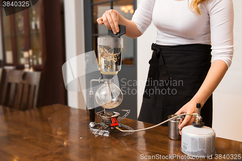 Image of close up of woman with siphon coffee maker and pot