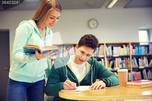 Image of happy students preparing to exams in library