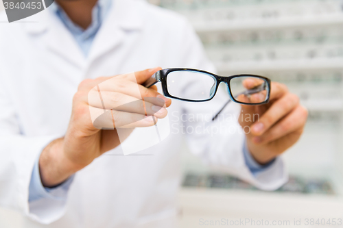 Image of close up of optician with glasses at optics store