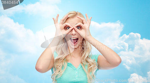 Image of young woman looking through finger glasses