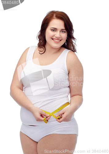 Image of happy young plus size woman with measuring tape