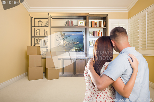 Image of Young Couple Looking At Drawing of Entertainment Unit In Room